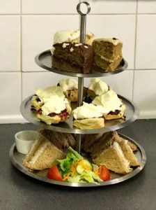 three tier cakestand filled with sandwiches , scones with jam and cream and cakes gift experience